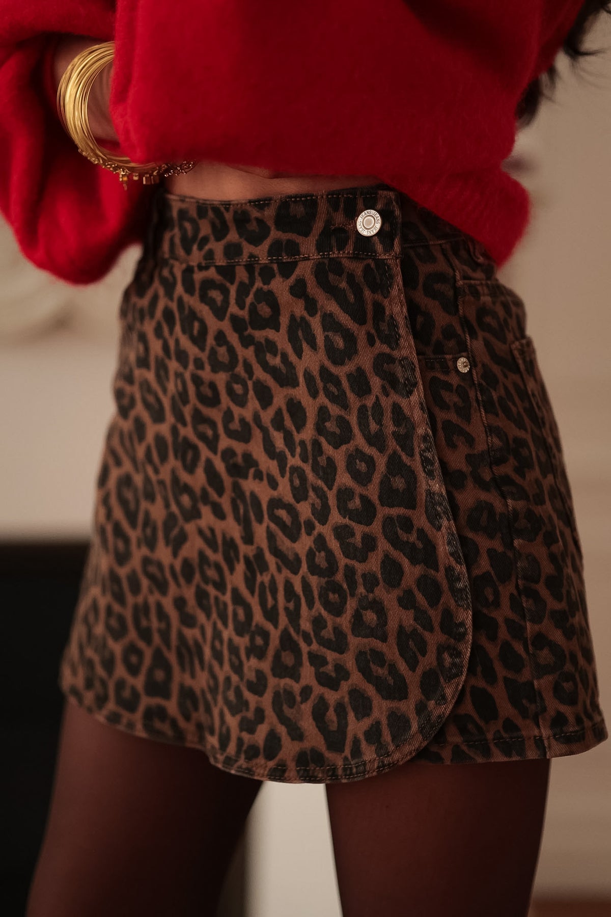 Jupe-short léopard marron et noire Amaya en jean, vue de face avec un pull rouge